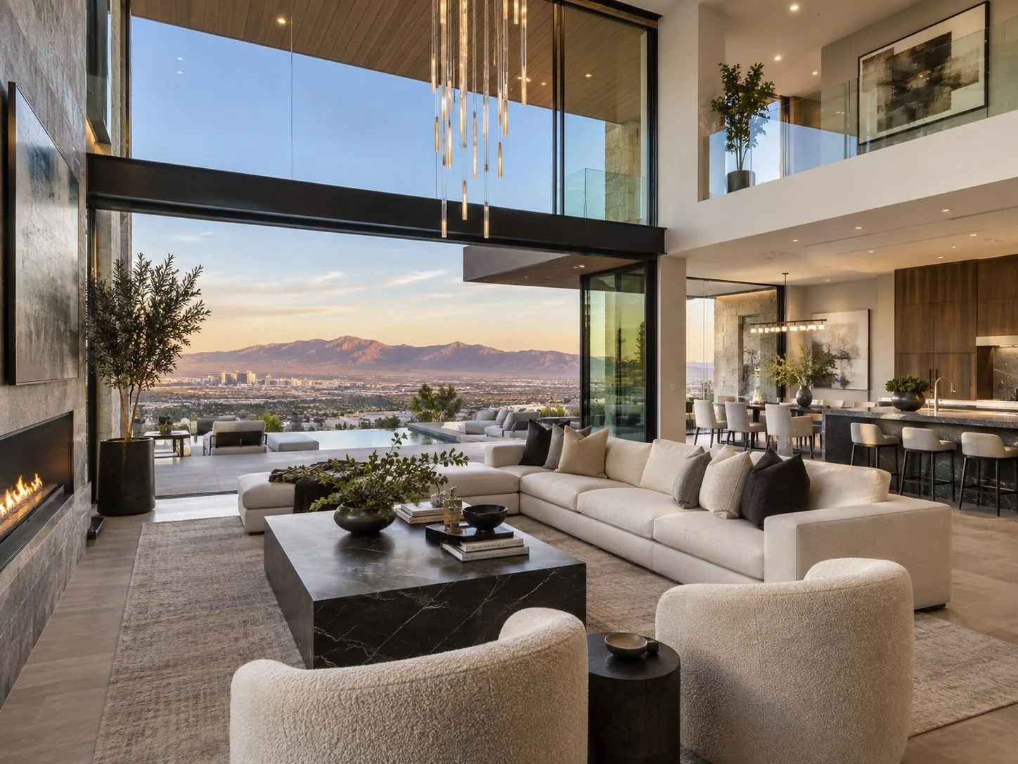 A grand Las Vegas hills home living room with floor to ceiling glass, a white sectional, and a sunset view over the valley