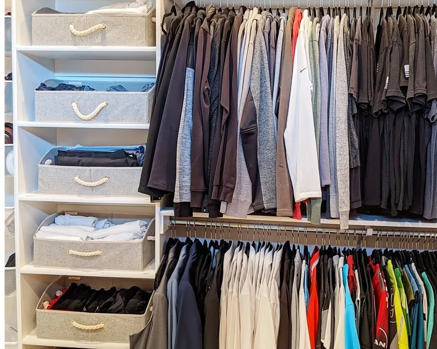 After: the same closet organized, with gray fabric bins on the same shelving and clothes hung in order on the same rails