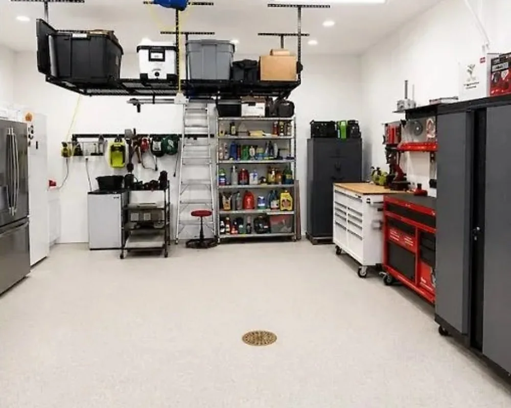 After: the same garage organized, with overhead racks loaded, back shelves sorted, the red tool chest in place, and a clear floor
