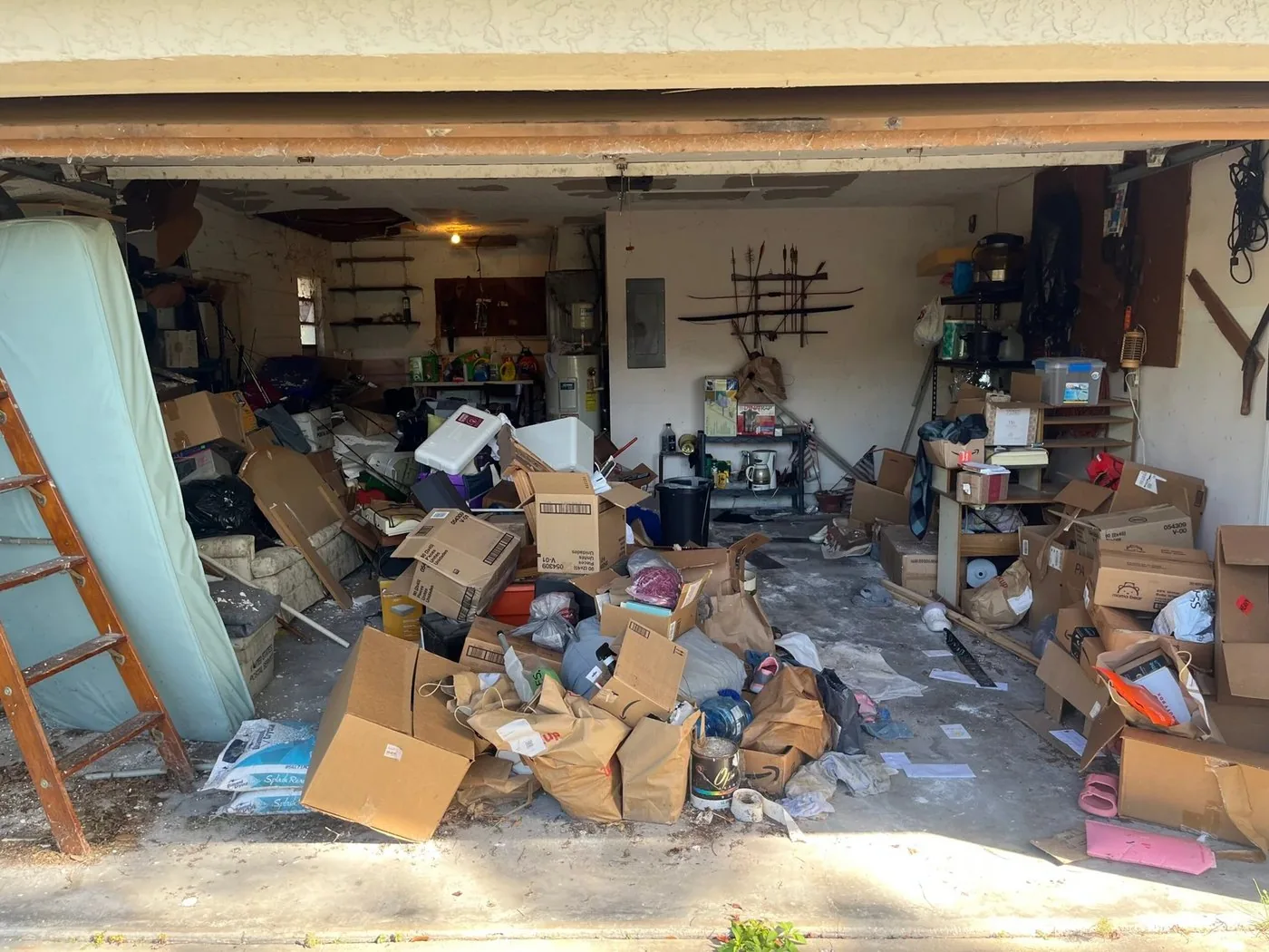 A garage packed with boxes, bags, and furniture, the starting point for most garage organization jobs