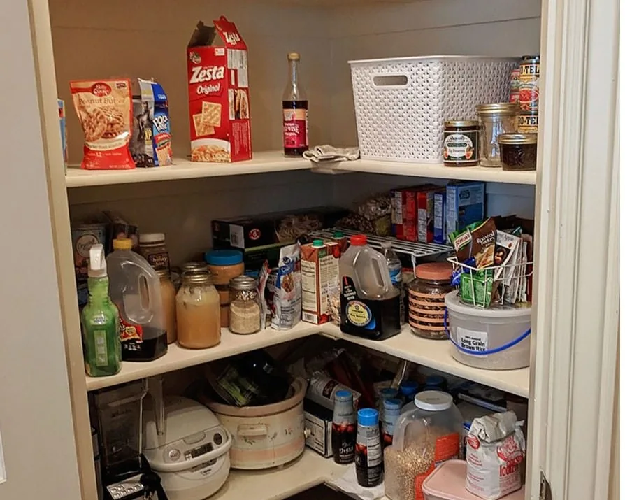 Before: the same corner pantry with crowded, jumbled shelves and food stacked wherever it fit
